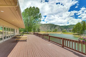 A wooden deck with benches overlooking a river, surrounded by trees and hills. - Snowy Avon Nights Near Vail & Beaver Creek (Avon)