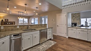 A modern kitchen with granite countertops, stainless steel appliances, and pendant lighting. - Snowy Avon Nights Near Vail & Beaver Creek (Avon)