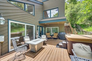 Una terraza con mobiliario exterior, una bañera de hidromasaje y una escalera que lleva a un segundo nivel.