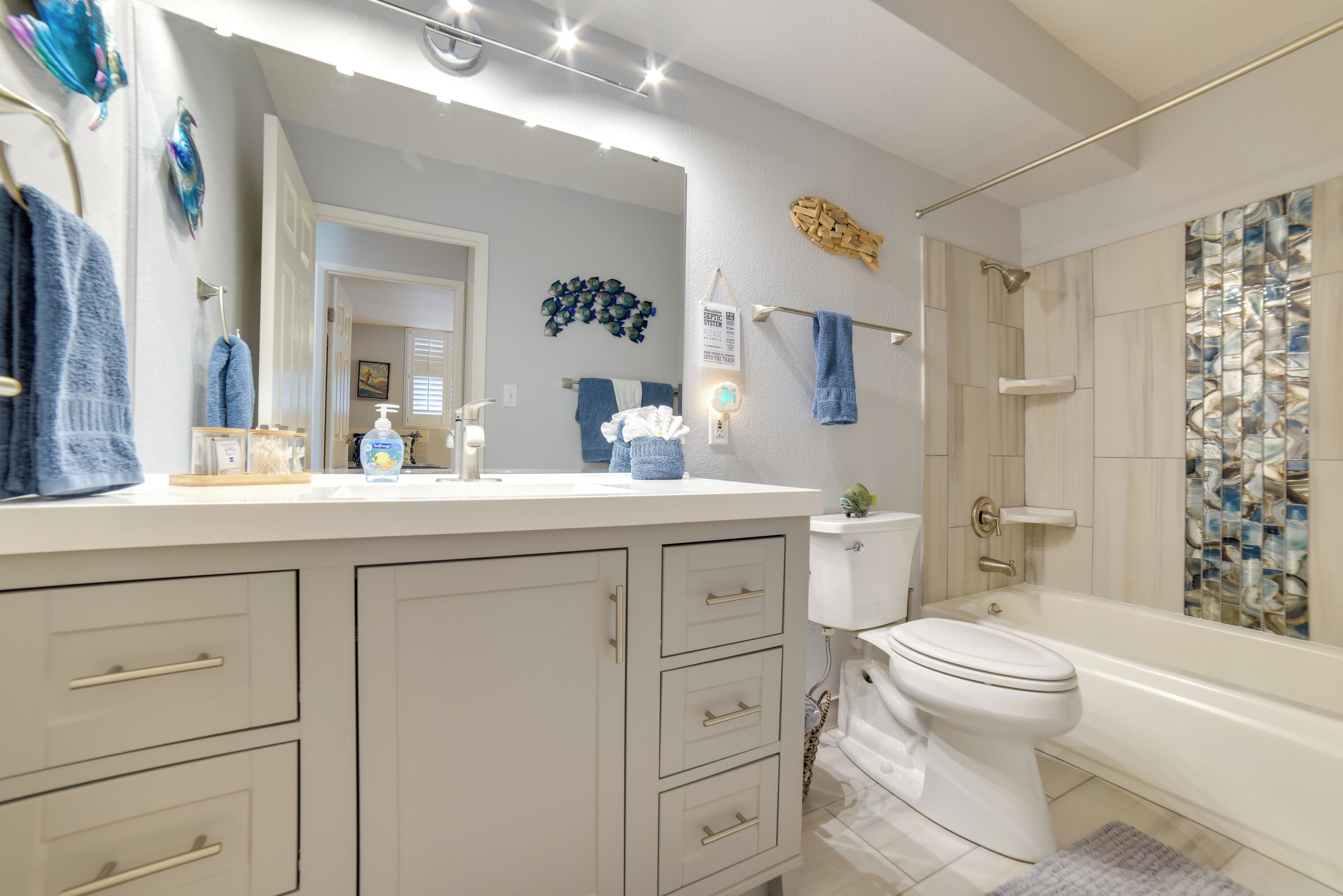 A bathroom with a white vanity, a toilet, a bathtub, and a shower.