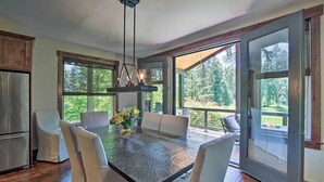 A spacious dining area with a large table, chairs, and a hanging light fixture. - Modern Alpine Home on Prospector Golf Course! (Cle Elum)