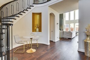 A staircase with black railings, a round table with chairs, and a large vase on the wall. - Spacious Texas Vacation Rental w/ Community Pool (Mansfield)