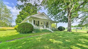 A two-story house with a covered porch, surrounded by well-maintained lawns and trees. - Historic Sparta Home Near Waterfalls & Hikes! (Sparta)