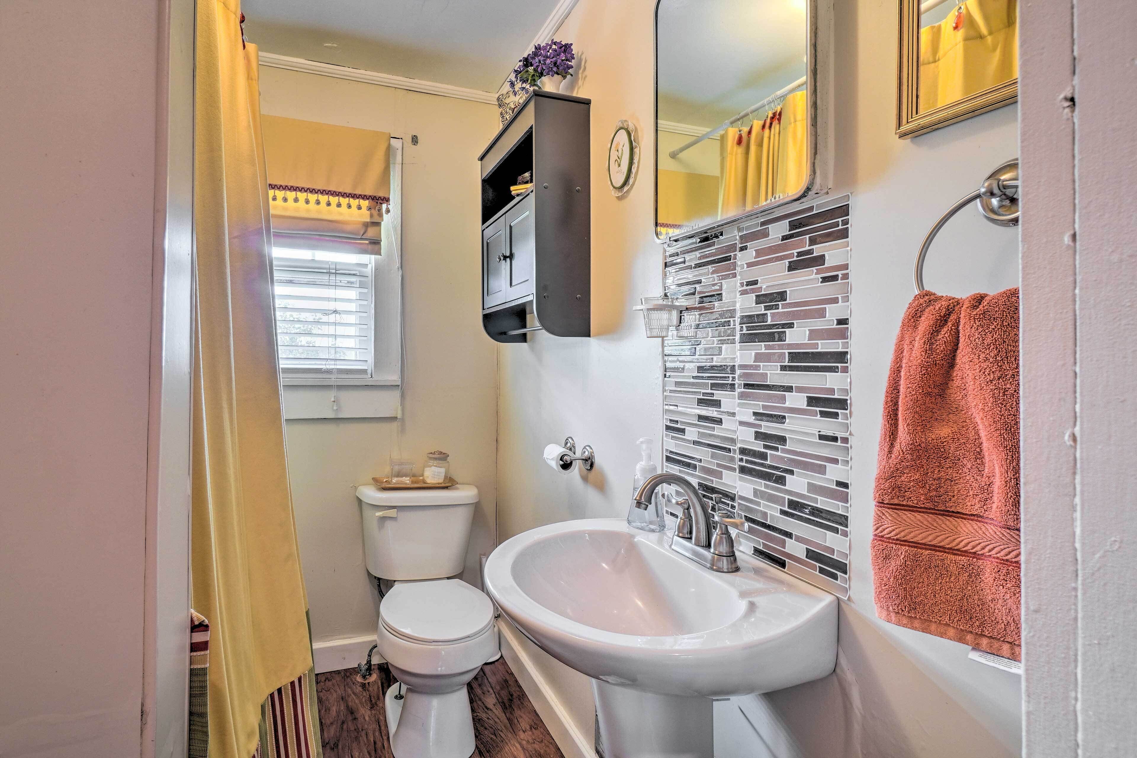 Une salle de bain avec des toilettes, un lavabo et un miroir.