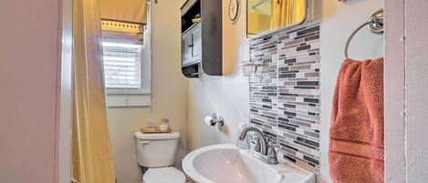 Une salle de bain avec des toilettes, un lavabo et un miroir.