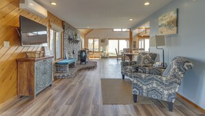 A spacious living area with a fireplace, a television, and patterned furniture. - Amazing Rocky Point Retreat Overlooking the Sound! (Rocky Point)