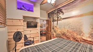 A bedroom with a bed, a fan, a TV, a window with a view, and a door leading to a dining area. - Walk to Waterfront: Dtwn Sturgeon Bay Retreat! (Sturgeon Bay)