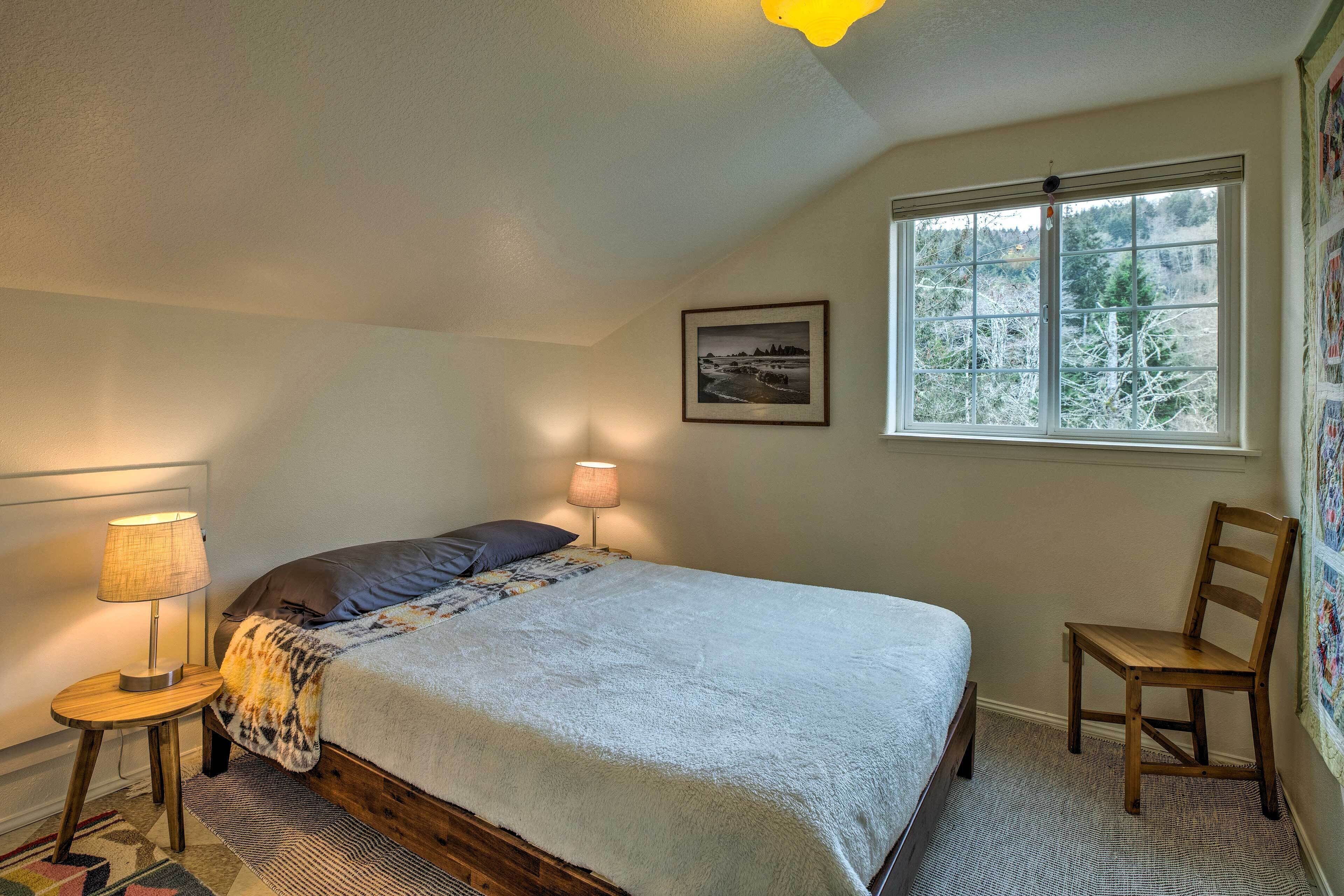 A bedroom with a bed, a chair, a lamp, a window, and a picture on the wall.