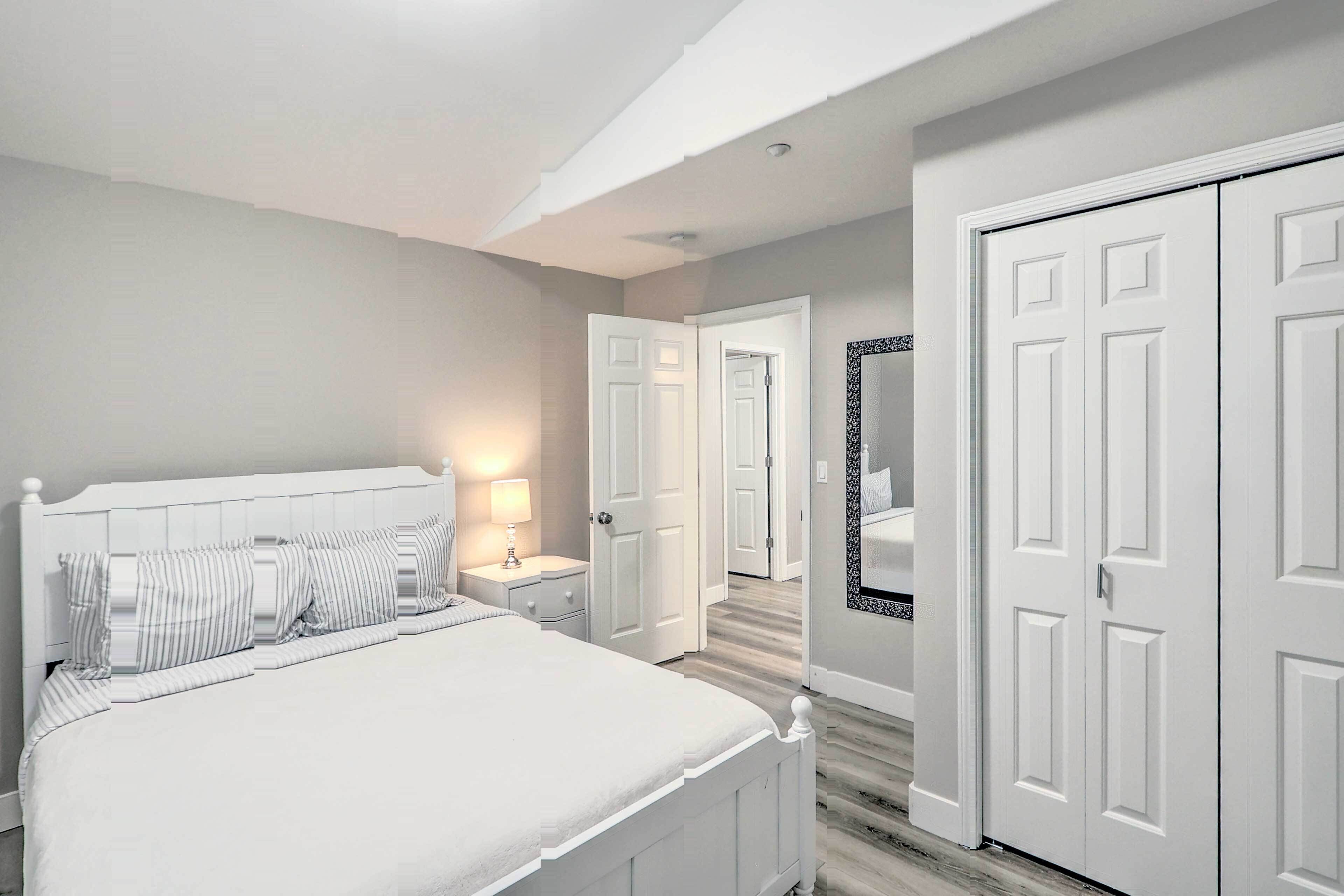 A bedroom with a bed, nightstand, and a mirror on the wall.
