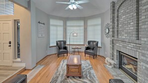A spacious living room with a fireplace, two leather chairs, a coffee table, and a ceiling fan. - Spacious Kent Home: Great for Large Families! (Kent)
