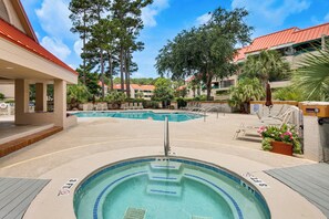 A swimming pool with a hot tub, surrounded by lounge chairs and palm trees. - 2 Mi to Beach! Hilton Head Golf Escape w/ Balcony (Hilton Head Island)