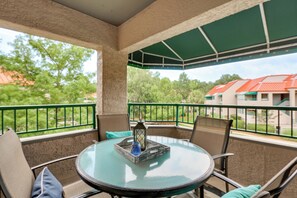 A covered outdoor seating area with a round table, chairs, and a view of greenery and buildings. - 2 Mi to Beach! Hilton Head Golf Escape w/ Balcony (Hilton Head Island)