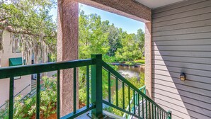 A balcony with a view of a river and greenery.