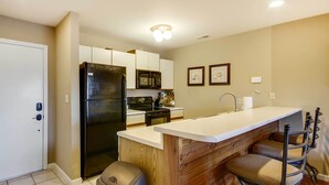 Kompakti keittiö, jossa on jääkaappi, mikroaaltouuni ja liesi. Keittiössä on myös puinen keittiösaareke, jonka yhteydessä on baarituoleja.
