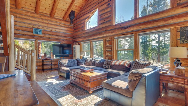 A log cabin interior with a large sofa, wooden coffee table, and a TV in the corner. - Access to Rocky Mtn Nat'l Park: Grand Lake Cabin (Grand Lake)