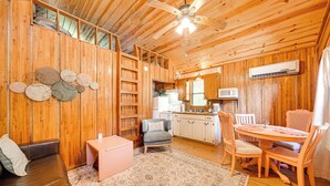 A wooden cabin interior with a dining area, kitchen, and seating space. - Rustic Cabin w/ Hot Tub Near Broken Bow Lake! (Broken Bow)