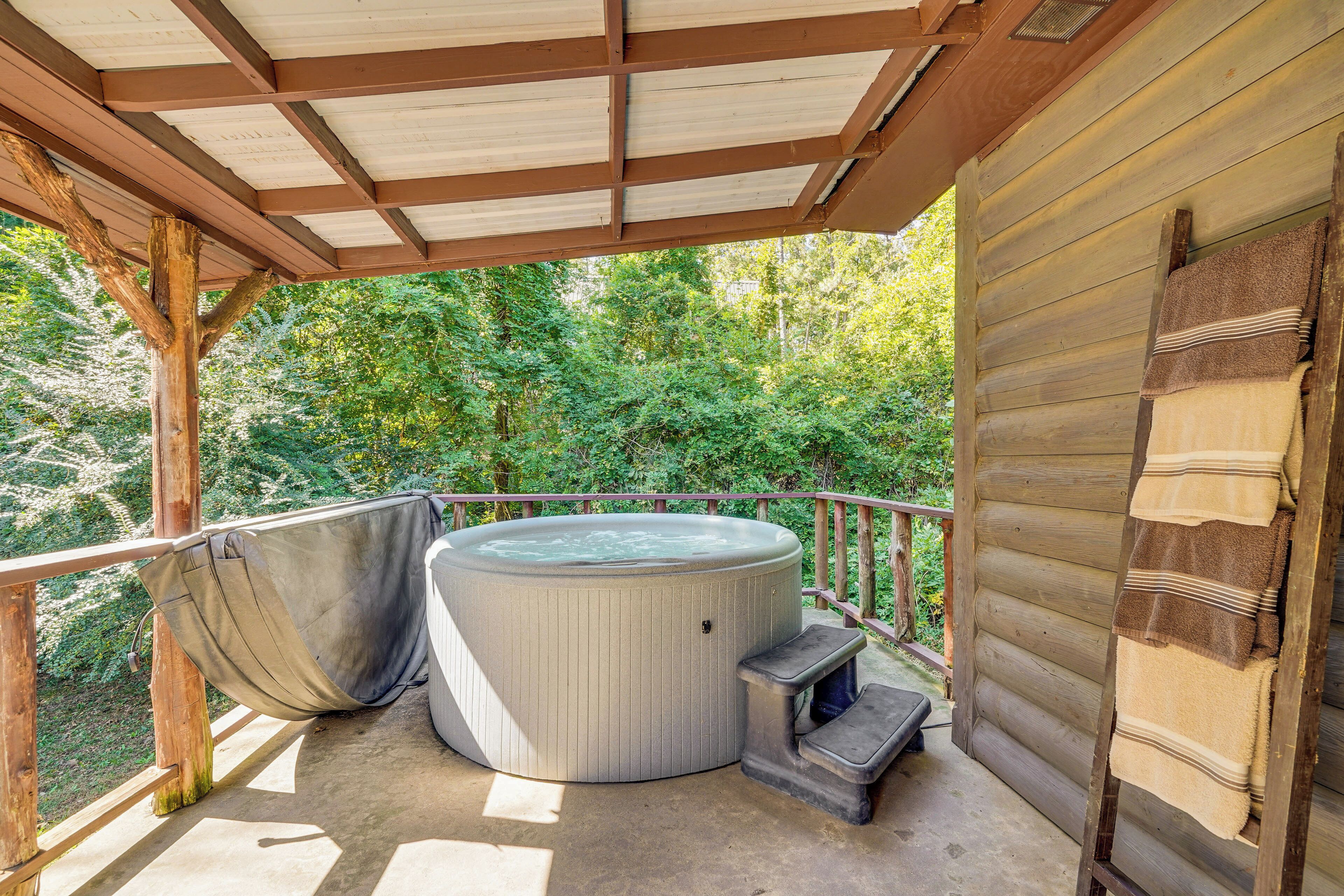 A hot tub on a wooden deck with a wooden railing and a covered area.