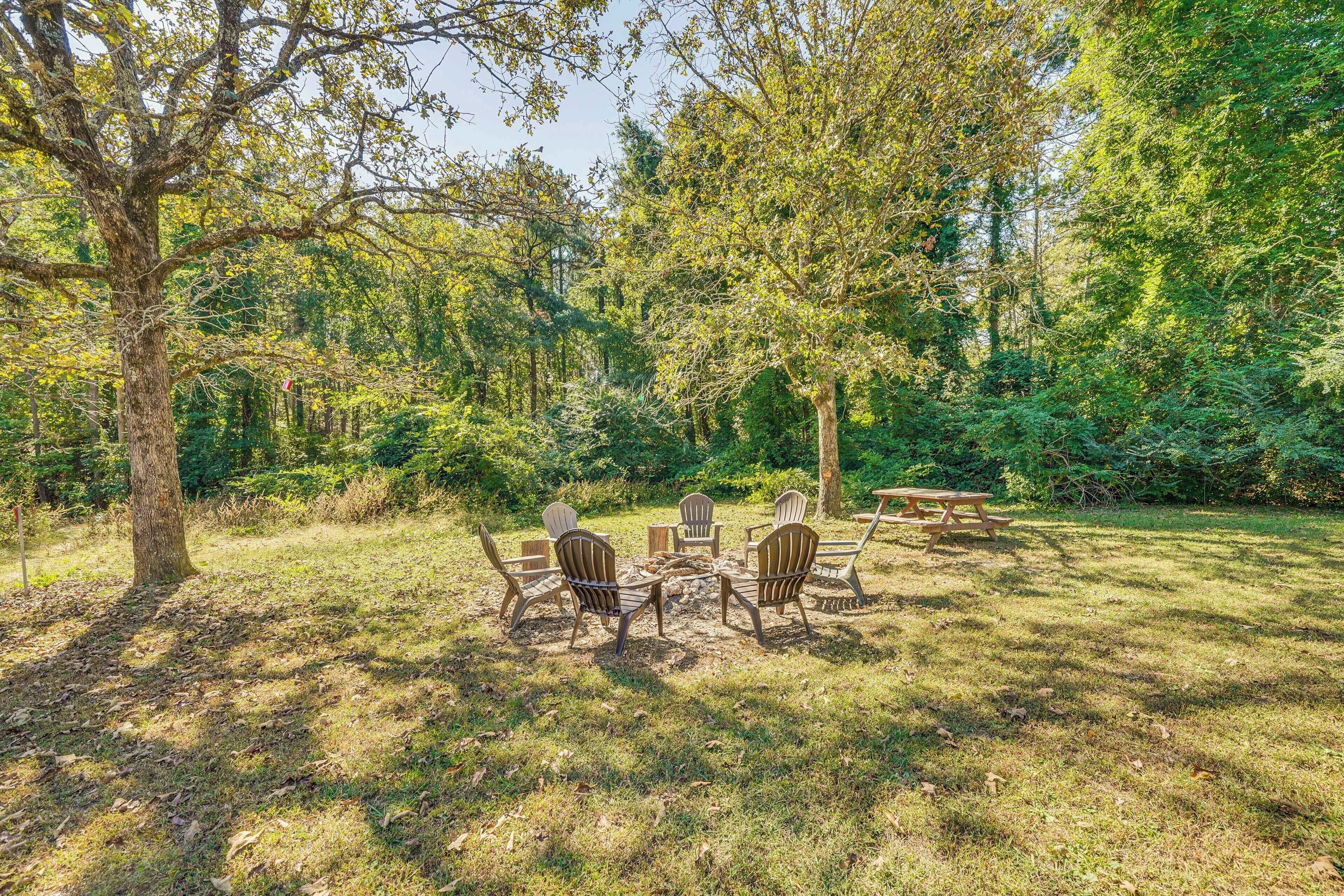 A picnic area with a table and chairs surrounded by trees.