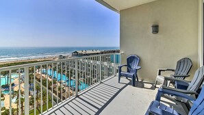 A balcony with a view of the ocean and a pool area. - South Padre Island Retreat w/ Beach Access! (South Padre Island)