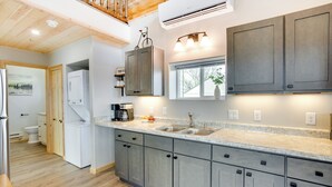 A modern kitchen with grey cabinets, a large island, and a window with a view. - Secluded Grand Junction Getaway w/ Sweeping Views! (Grand Junction)