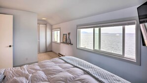 A bedroom with a large window, a bed, and a door leading to another room. - Oceanfront Ferndale Oasis w/ Fire Pit, Grill! (Ferndale)