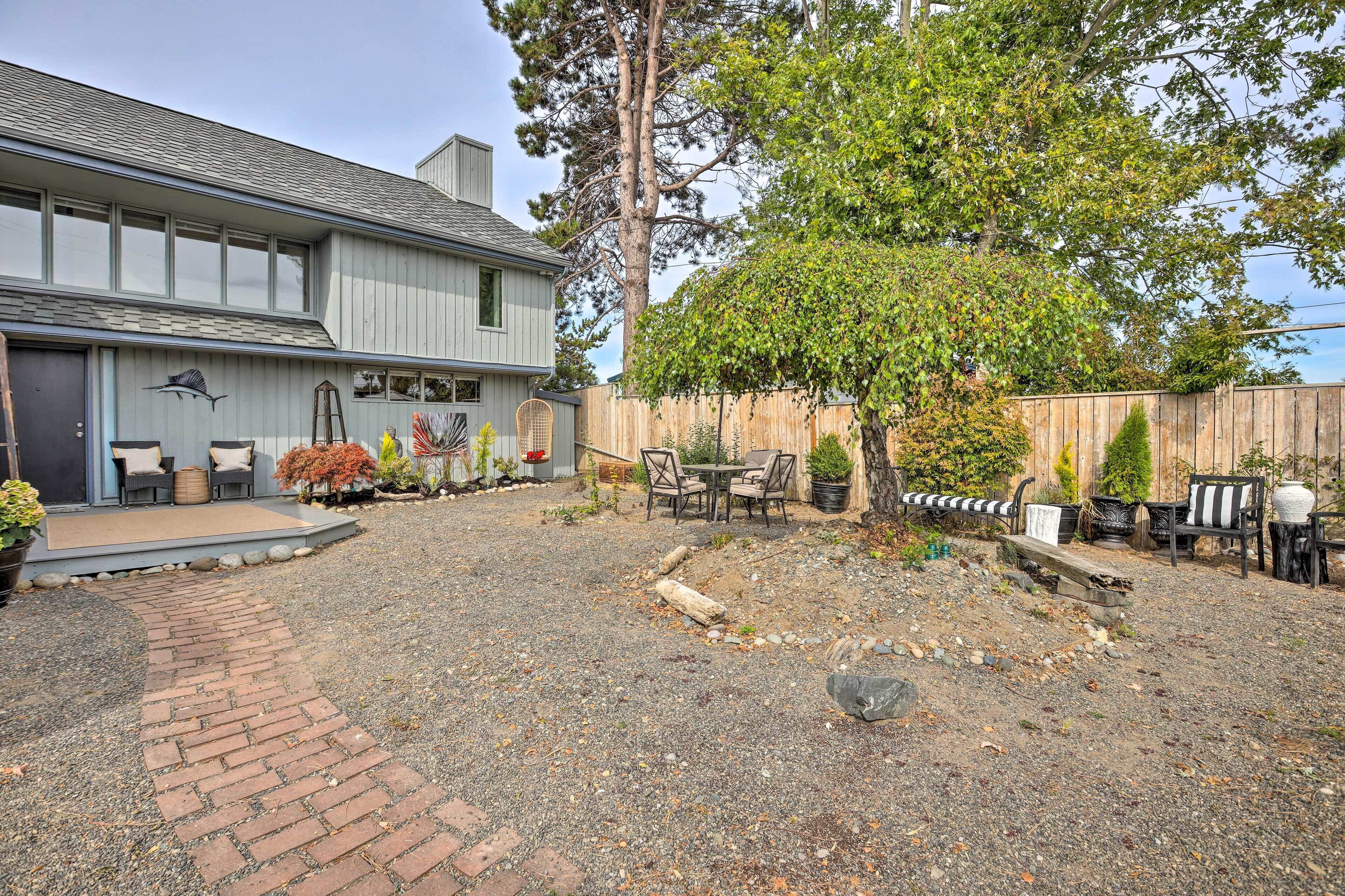 A house with a gravel driveway, a brick pathway, and outdoor furniture.
