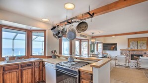 A kitchen with wooden cabinets, a built-in oven, and a hanging pot rack. - Oceanfront Ferndale Oasis w/ Fire Pit, Grill! (Ferndale)