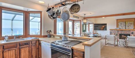 A kitchen with wooden cabinets, a built-in oven, and a hanging pot rack.