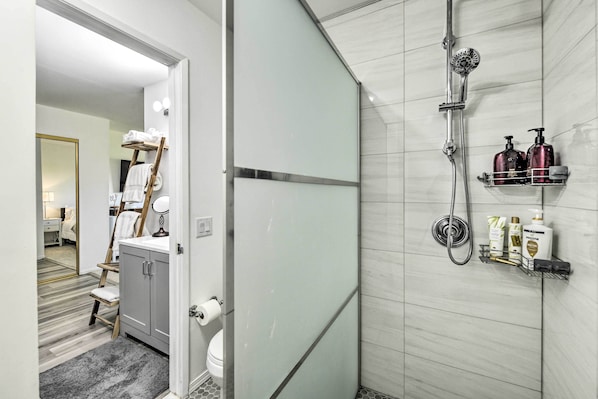 A modern bathroom with a shower, toilet, and vanity. - Pool Access: Pet-friendly Bermuda Dunes Condo (Indio)