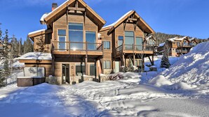 A large wooden lodge with multiple balconies and a snow-covered landscape.