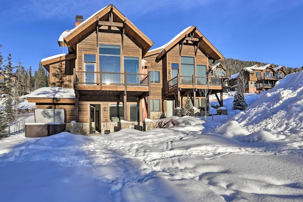 A large wooden lodge with multiple balconies and a snow-covered landscape.