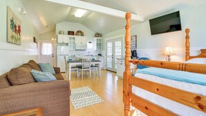 A cozy room with a wooden bed, a sofa, a dining area, and a kitchen. - Ranch Cabin w/ Decks, 10 Mi to Fredericksburg (Fredericksburg)