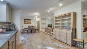 Eine geräumige Küche mit Holzausstattung, einem Essbereich mit Tisch und Stühlen sowie einem Einbauschrank mit Schubladen.