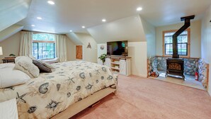 A bedroom with a bed, a TV, a fireplace, and a stone wall. - 'lakeside Bear Lodge' Studio: 9 Mi to Bass Lake! (Wishon)
