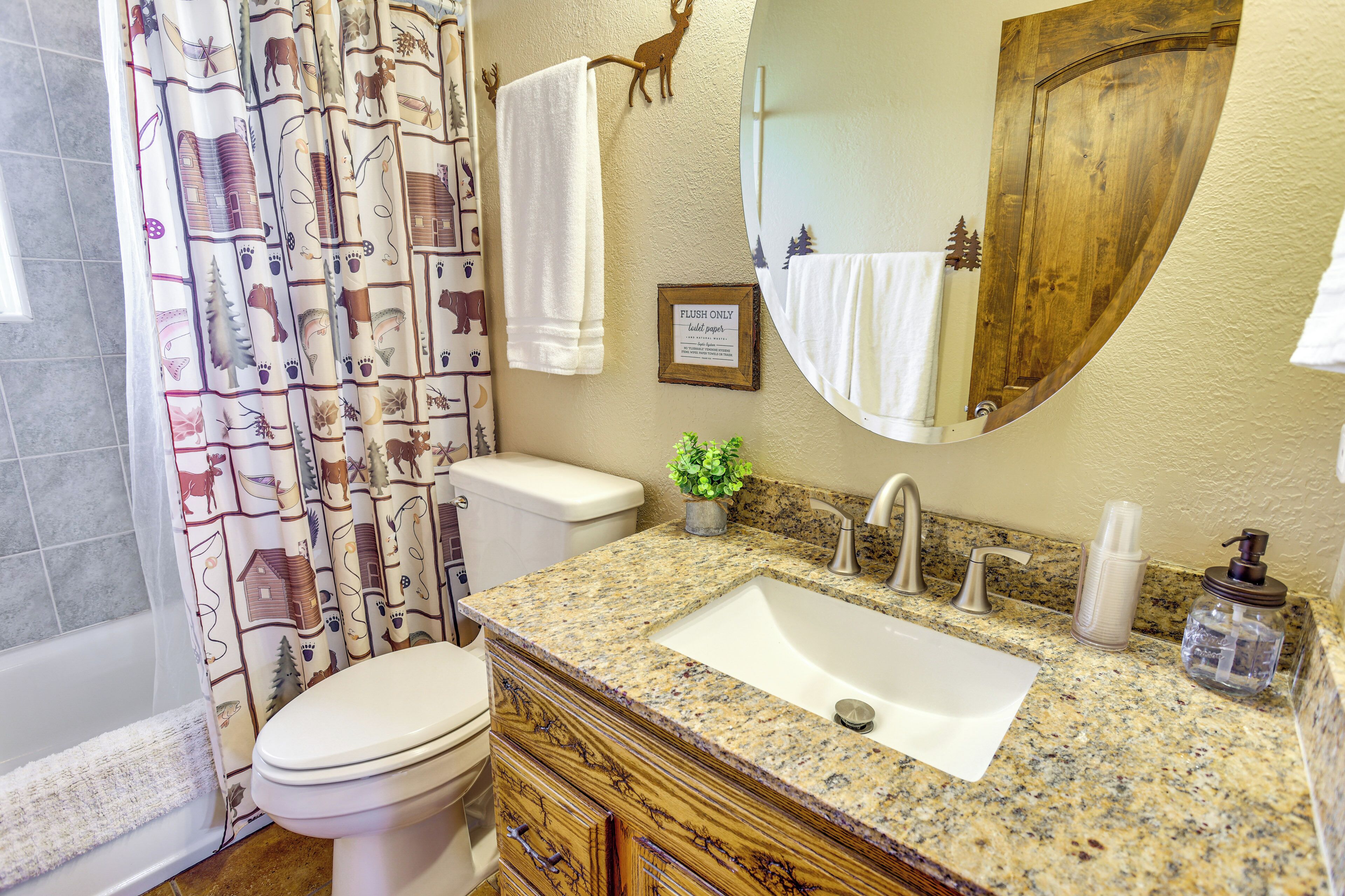 A bathroom with a toilet, sink, and shower curtain.