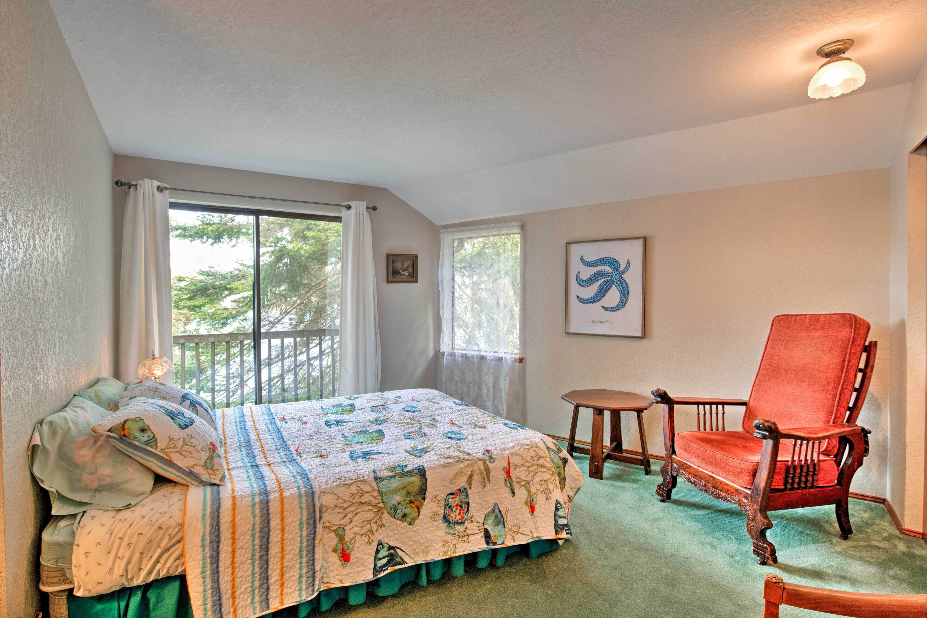 A bedroom with a bed, a chair, a small table, and a window.