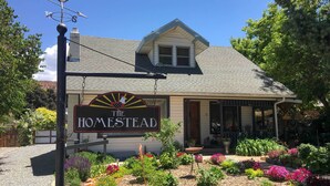 A house with a sign reading "The Homestead" and a garden with various plants and flowers. - Charming Cedar City Retreat - Walk to Downtown! (Cedar City)