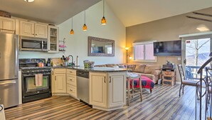Una cucina moderna con isola centrale, elettrodomestici in acciaio inossidabile e pavimento in legno.