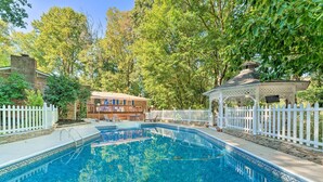 A swimming pool with a white fence, a gazebo, and a building with a bar in the background. - Dobson Getaway w/ Private Pool & Game Room! (Dobson)