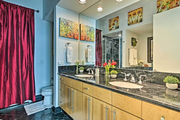 A modern bathroom with a double sink, vanity, and a large mirror.