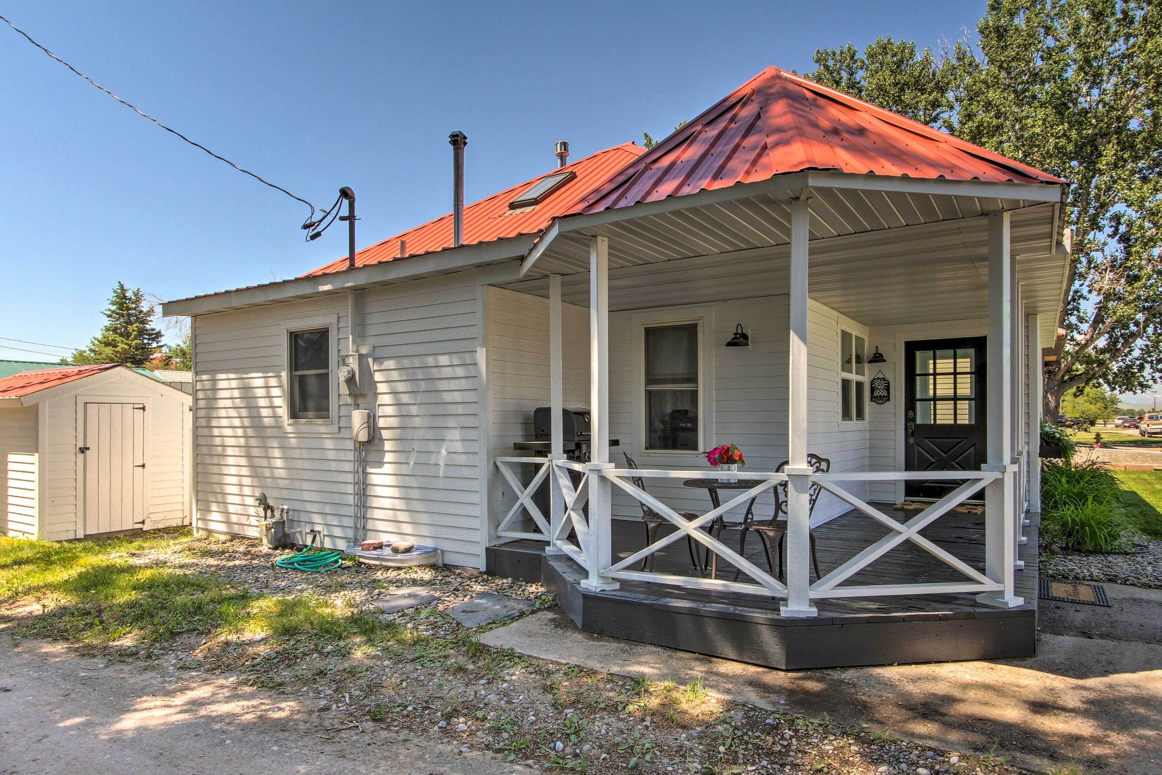 A single-story house with a porch, a garage, and a red roof.