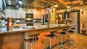 A kitchen with a central island, bar stools, and a rustic ceiling. - Willamette Valley Apt - Surrounded by Wineries! (Hillsboro)