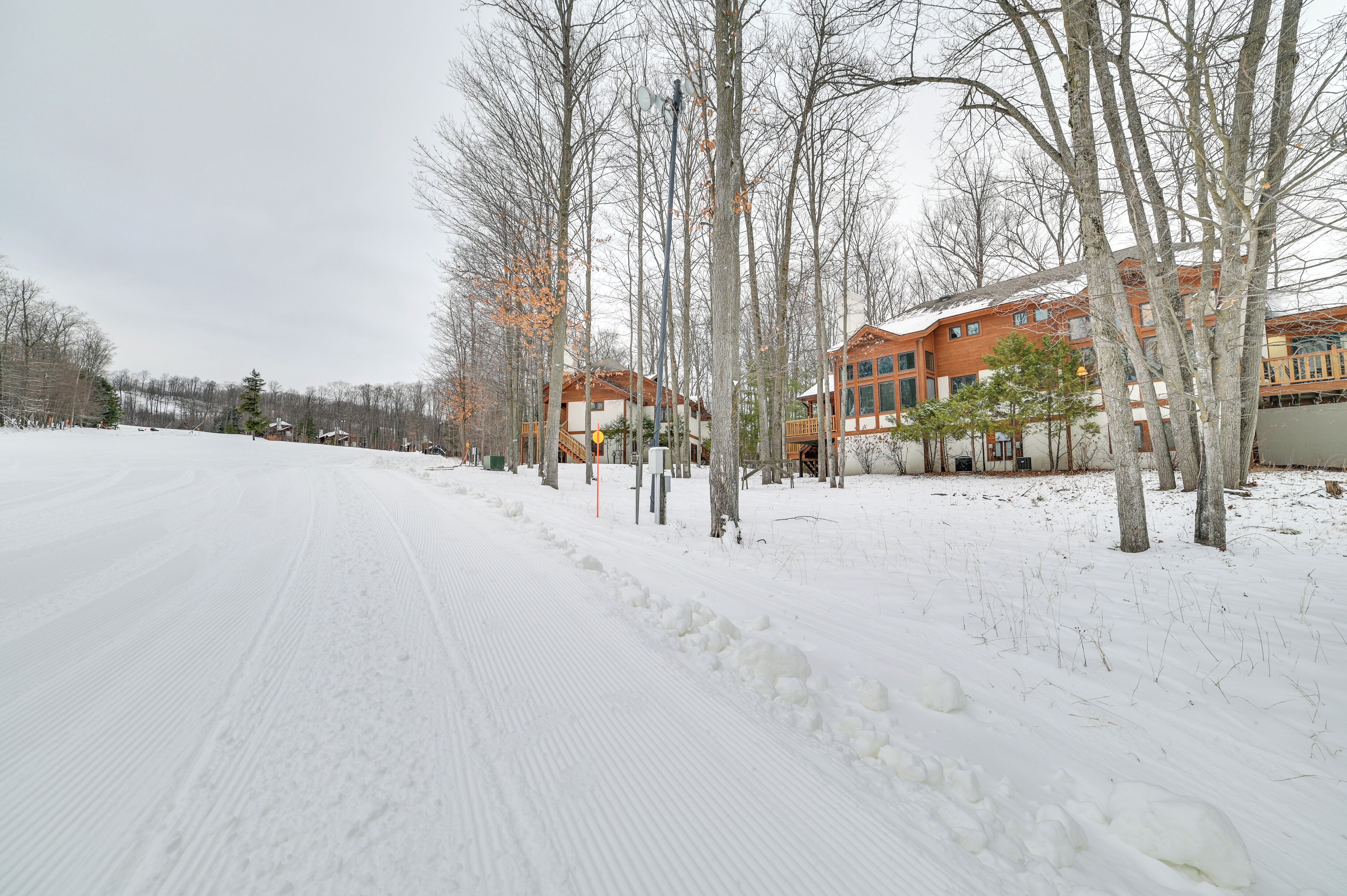 En snötäckt väg med byggnader i bakgrunden.