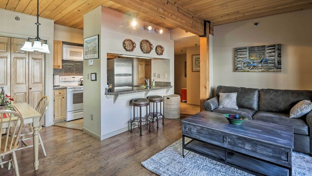 A modern kitchen with wooden cabinets, a built-in oven, and a large island with stools. - Cozy Crested Butte Condo - Walk to Ski Lift! (Crested Butte)