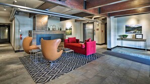 A modern lobby with a fireplace, red sofas, and a patterned rug. - Cozy Crested Butte Condo - Walk to Ski Lift! (Crested Butte)