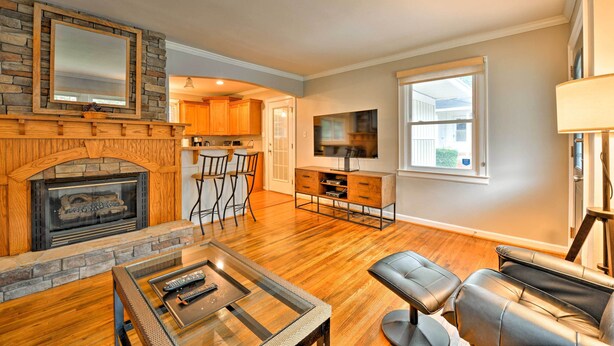 A living room with a fireplace, a TV, and a dining area with chairs.