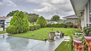 A residential driveway with a well-maintained lawn, potted plants, and a stop sign in the background. - Apartment w/ Patio: 15 Miles to French Quarter! (Westwego)