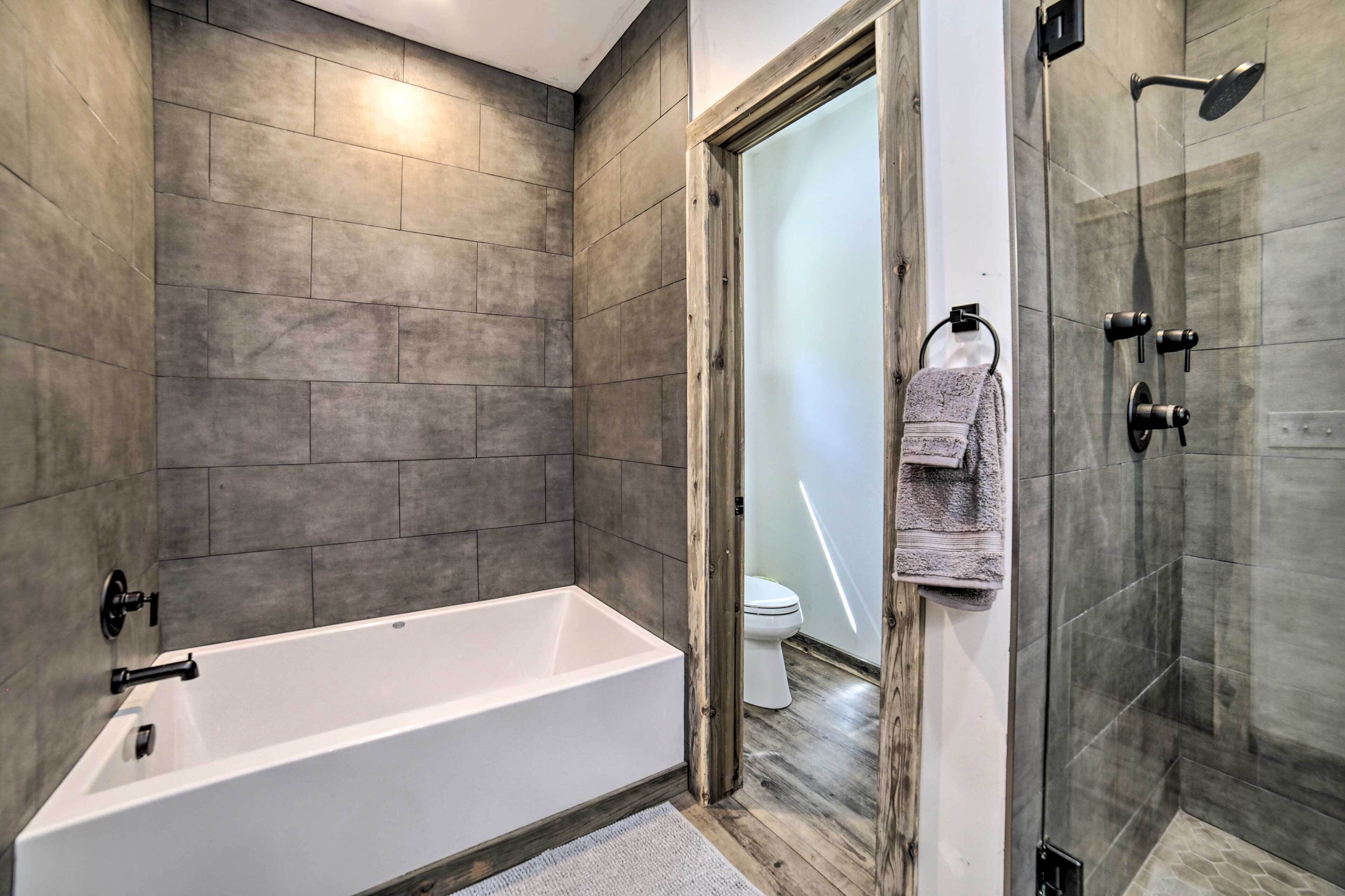 A modern bathroom with a bathtub, a shower, and a toilet.