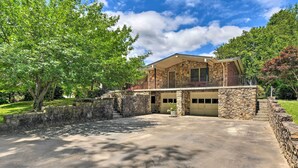 A two-story stone house with a balcony, a garage, and a paved driveway. - Cozy Charlotte Retreat w/ Yard ~ 5 Mi to Dtwn (Charlotte)
