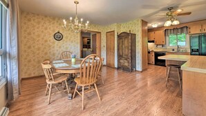 A dining area with a wooden table and chairs, a chandelier, and a clock on the wall. - Cozy Charlotte Retreat w/ Yard ~ 5 Mi to Dtwn (Charlotte)